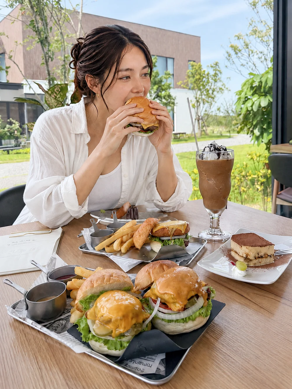 賓客在日光窗邊享用漢堡、薯條與飲品的用餐情境