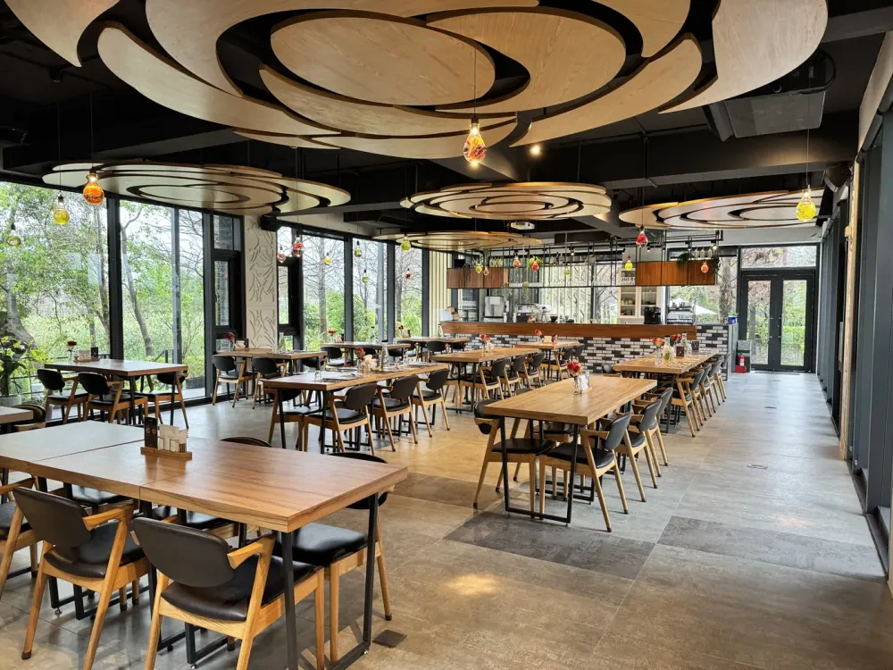 F 館餐廳的木質餐桌、大片落地窗與花形天花板
